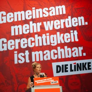 Antje Feiks spricht an einem Redepult auf dem Bundesparteitag in Leipzig. Im Hintergrund steht in großen Lettern "Gemeinsam mehr werden. Gerechtigkeit ist machbar."